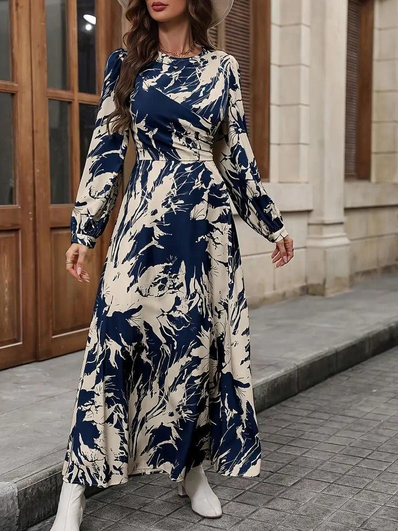 Burning Bones Allover Print Crew Neck Dress featuring elegant navy and cream abstract floral pattern, long bishop sleeves, fitted waist, and flowing ankle-length silhouette. Maxi dress showcased in outdoor setting with classic architectural backdrop.